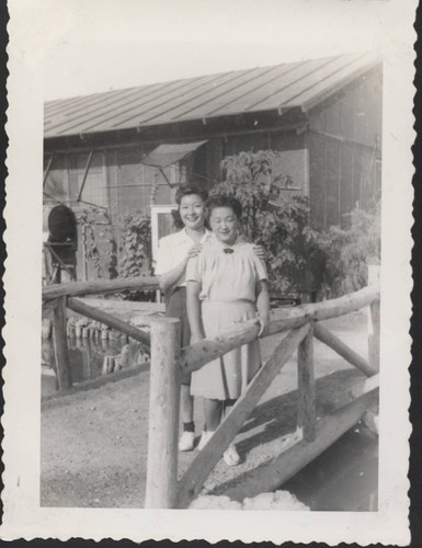 Two women on a bridge over water at Poston incarceration camp