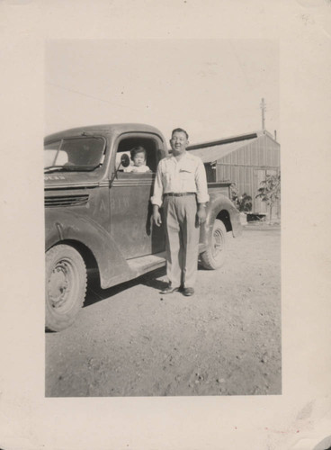 Man, child, and truck at Poston incarceration camp