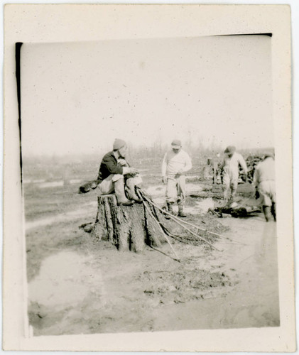 Man sitting on tree stump at incarceration camp