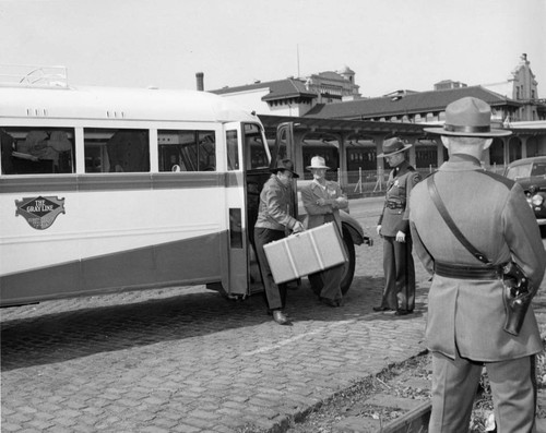 Indonesians leaving buses at the Southern Pacific depot in San Francisco, to board a train to take them to the immigration detention facility at Crystal City, Texas