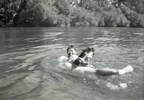 Two people playing in a river