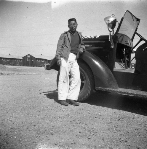 Nisei man with vehicle in Jerome camp