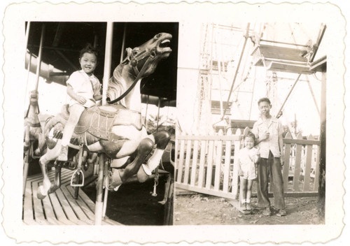 Gerrie Miyazaki on merry-go-round; Gerrie Miyazaki standing next to Yoshio Narita