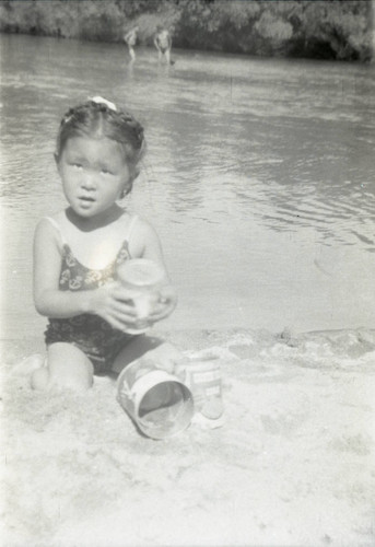 Child playing in sand at a river beach