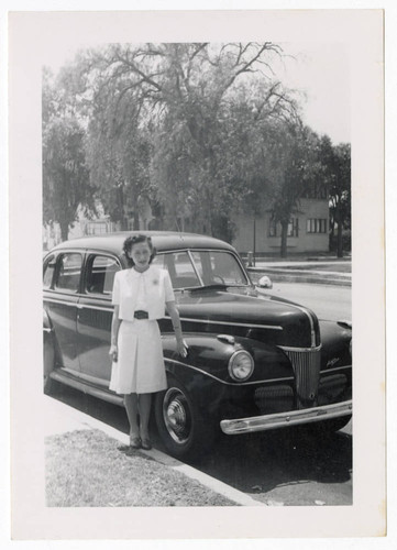 Nisei woman standing next to car