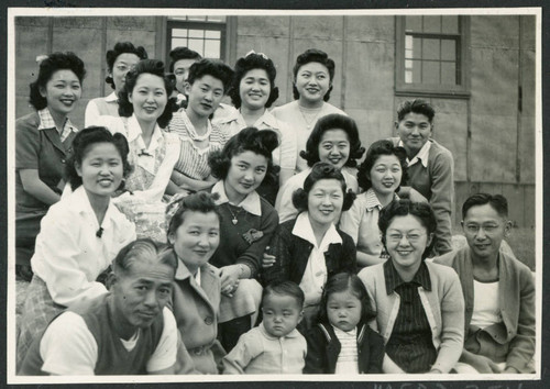 Photograph of a group of people posing in front of the Manzanar hospital