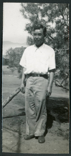 Photograph of "man of all trades" posing in front of a tree at Manzanar