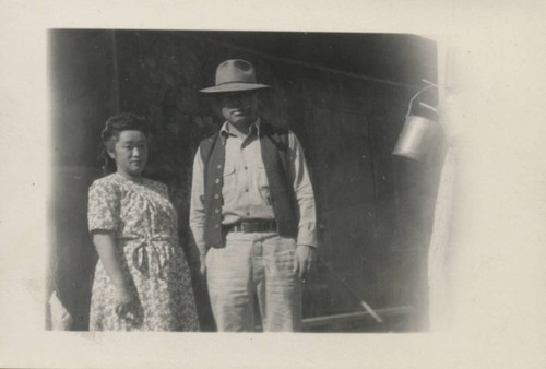 Man smoking a pipe and woman at Poston incarceration camp