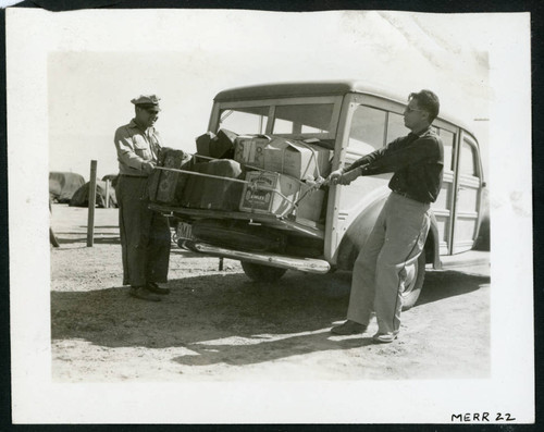 Patrolman Howard Kumagai and Ass't. Chief Kiyoshi Higashi assist in the routine departures from the police station