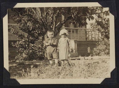 Boy and girl in front of a bungalow house