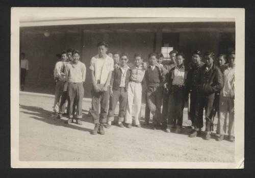 Young men gather in front of Poston II High School