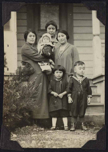 Women and children outside bungalow home