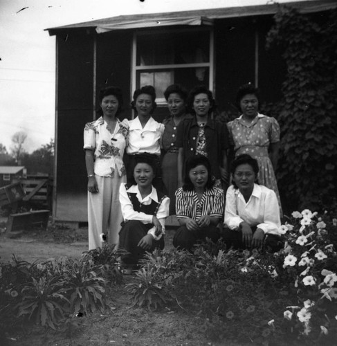 Group photograph of Nisei women in garden in Jerome camp