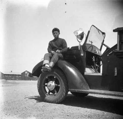 Nisei man on vehicle in Jerome camp