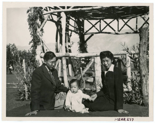 Photograph of Lillian and Harry Matsumoto with an infant at the Children's Village park in Manzanar