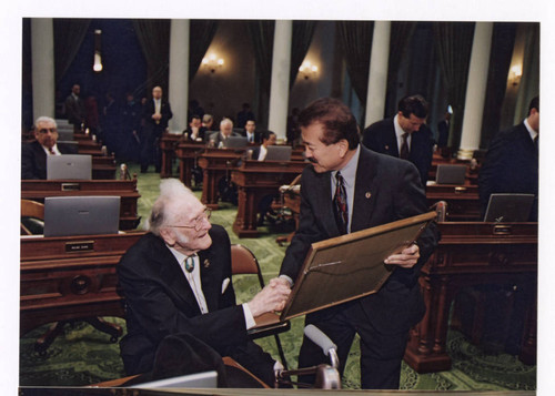 George Nakano giving Ralph C. Dills an Assembly Resolution