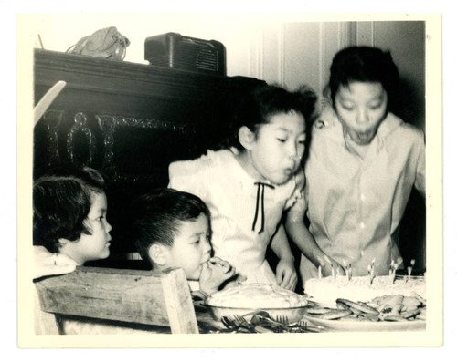 Young girl blowing out candles