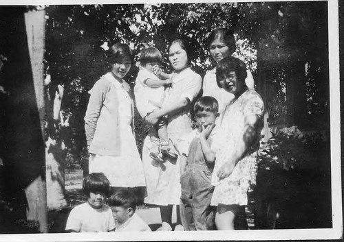 [Mrs. Taniguchi and family in orchard]