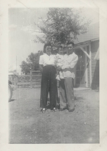 Young family in front of house at Poston incarceration camp