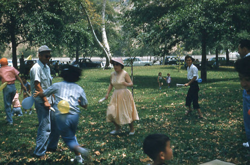 Women, children, and men playing a game