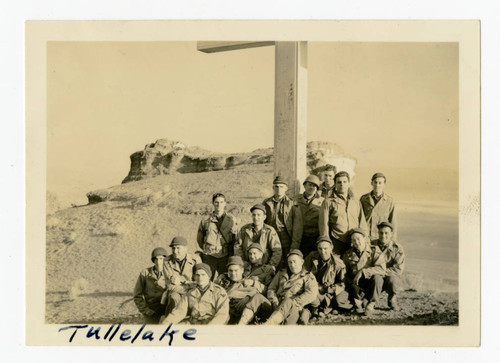 Group poses next to cross