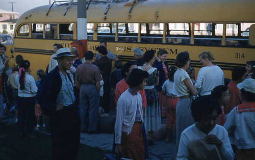 Men, women, and children in front of bus