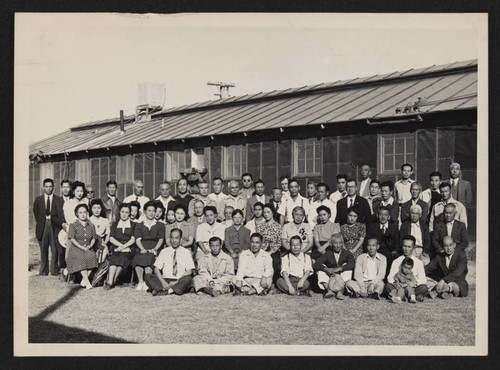 Group photo in front of incarceration camp barracks