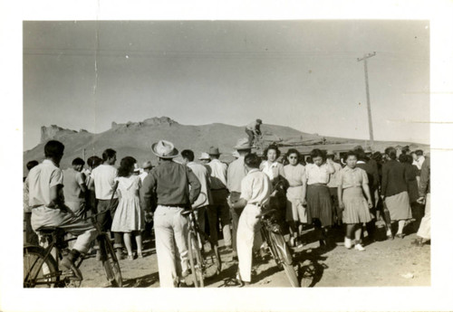 [People gathering around a vehicle covered in baggage]