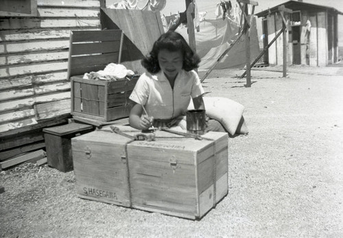 Woman painting label on a crate