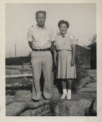 Couple pose next to landscaped pond at Poston incarceration camp