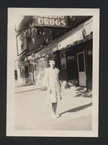 Photograph of Suzuki family member in front of Suzuki Drugs