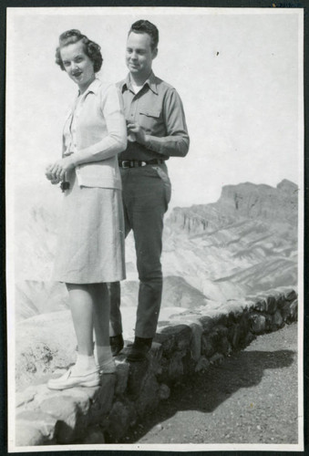 Photograph of Cleo and Pete Merritt standing on a short wall at Zabriskie Point in Death Valley