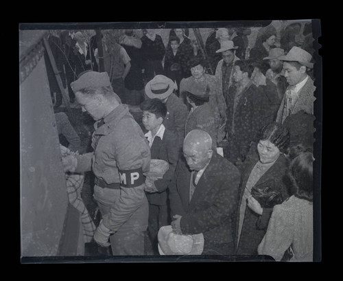 Crowd waits to board a train for "evacuation" at Terminal Island