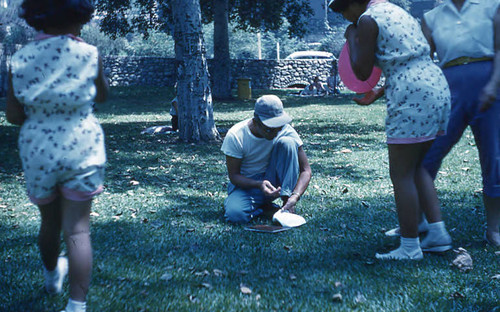 Man kneeling on grass at Little Miss picnic