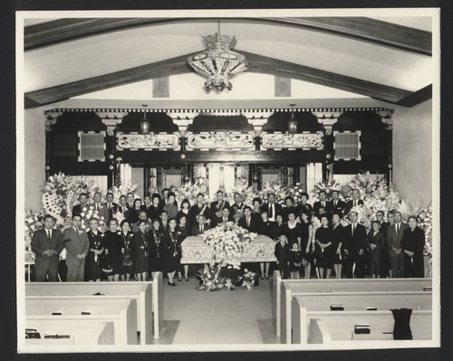 Mourners by coffin in Buddhist church