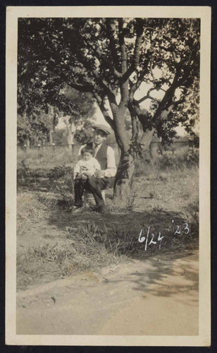 Man and child relaxing under tree