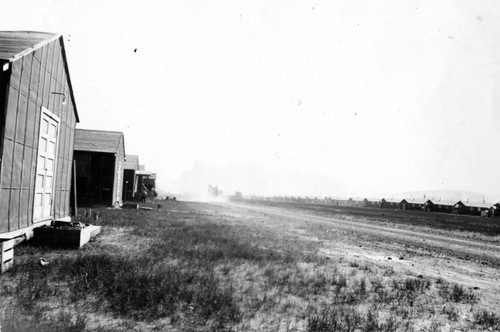 [Camp buildings with dust cloud]