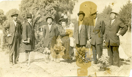 [Japanese American men, women, and children in a cemetery]