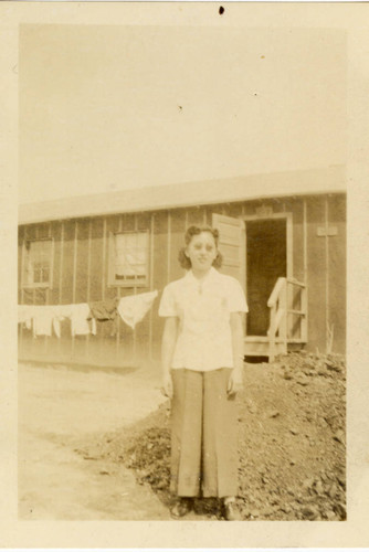 Woman standing in front of camp barrack