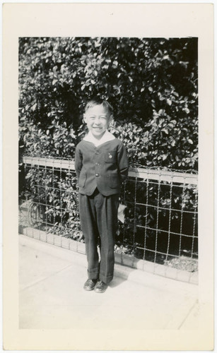 Yoshio Narita in front of fence