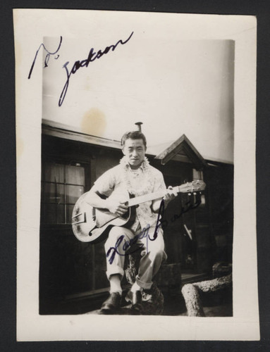 Member of the Paradise Melodiers band playing guitar at Tule Lake