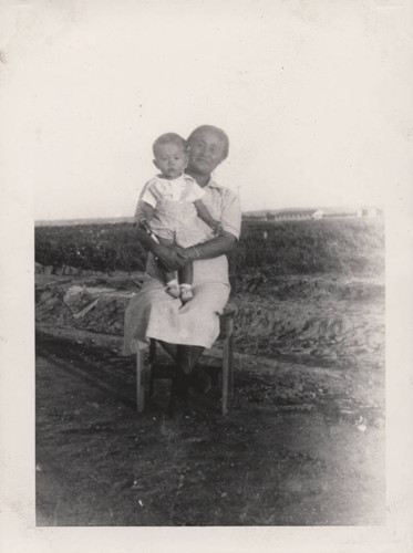 Woman holding baby on lap at Poston incarceration camp