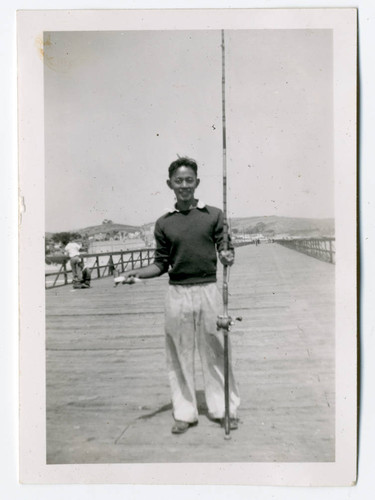 John Yoshinaga holding fishing pole