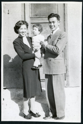 Photograph of Jean and Togo Tanaka with daughter Iye posing in front of a door in Cow Creek Camp in Death Valley