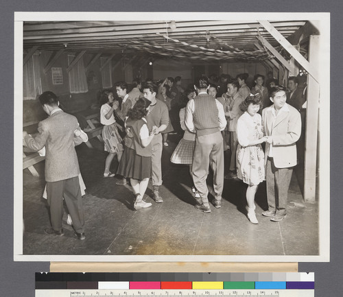 Young Japanese Hold Dance. Messhall movies, Littletheatre activities and jitter-bugging to evacuee bands are popular forms of entertainment at the TuleLake, Calif., Japanese Relocation Center. Here a block dance is in progress. Note the "zoot suit" pants