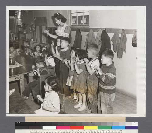 Japanese Tots under Supervision of Aiko Sumoge, assistant teacher, sing an English folk song in class at the Tule Lake Calif., Japanese Relocation Center