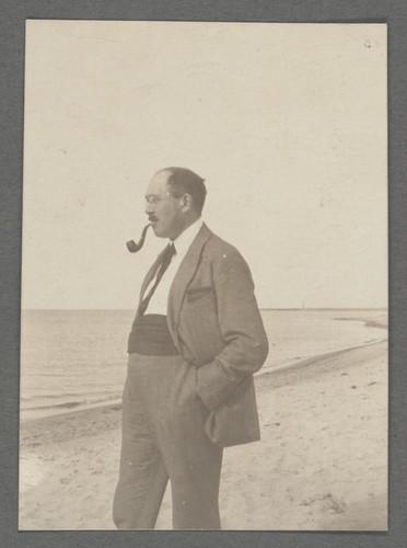 [Otto Stern on beach with pipe in mouth, looking toward ocean.]