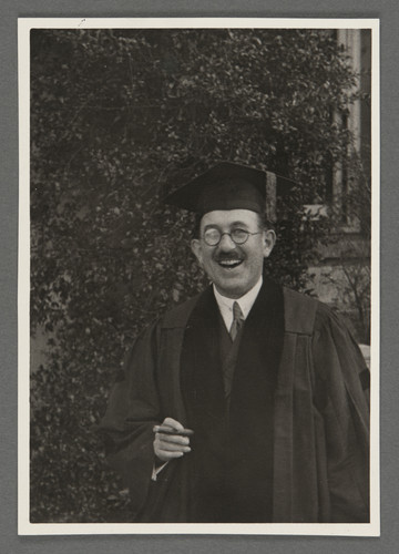 [Otto Stern in academic cap and gown, holding a cigar.]