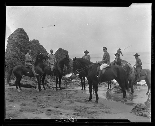 Men on horseback on beach