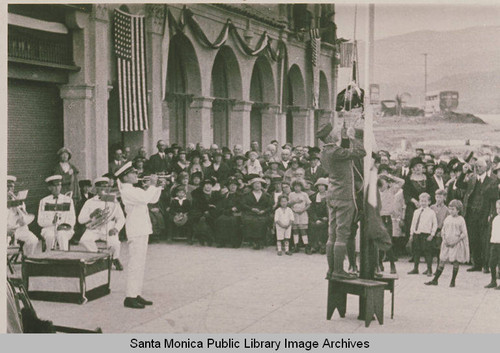 A flag is being raised and a band celebrates the founding day of the Business Block in downtown Pacific Palisades